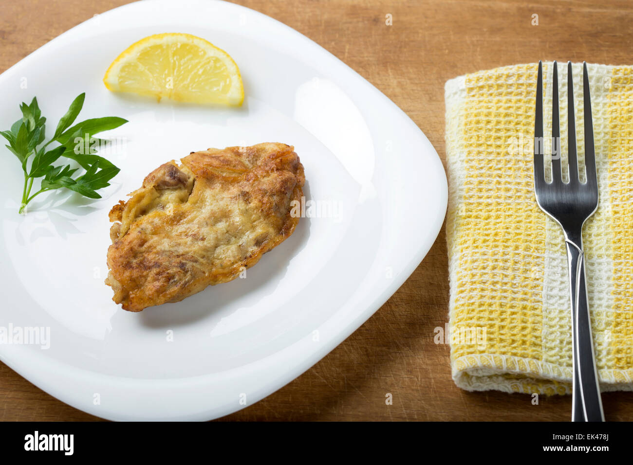 Maiale fritto cervelli con limone e prezzemolo sulla piastra Foto Stock