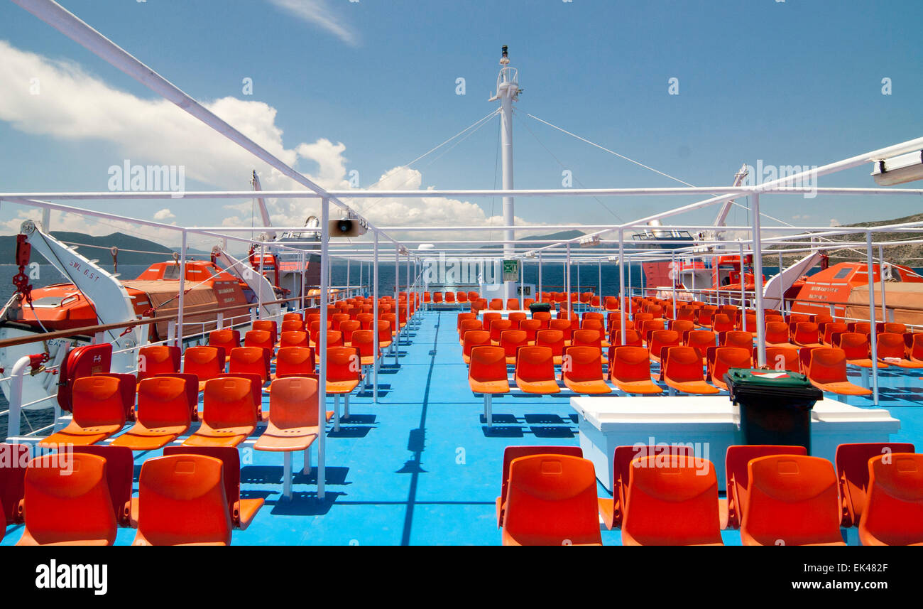 Vuoto sedie di colore arancione sul ponte della nave Foto Stock