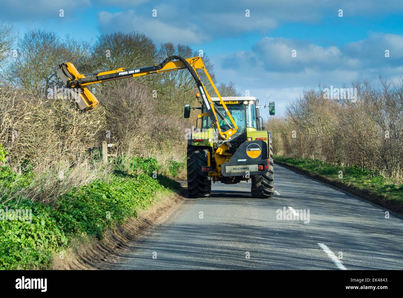 Meccanizzata di taglio di siepi sulla strada di un paese Foto Stock