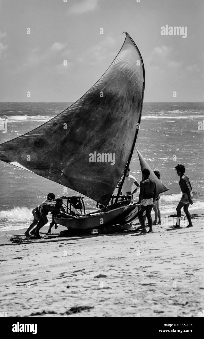 Il Brasile, la gente tira una barca (Jancada) sulla spiaggia di Canoa Quebrada village (175 km da Fortaleza) - Scansione su pellicola Foto Stock