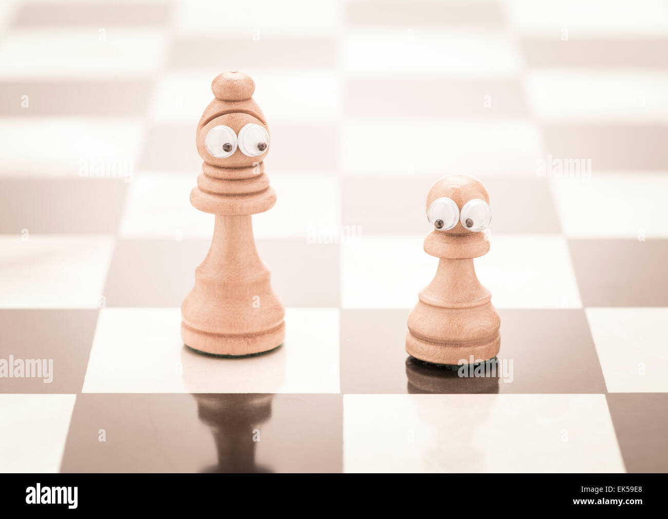 Pezzi di scacchi con gli occhi. Immagine concettuale della genitorialità come madre single. Foto Stock