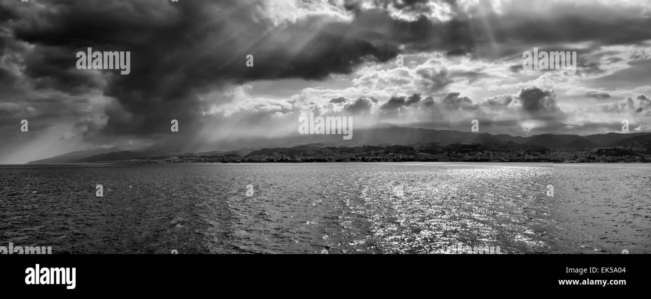 L'Italia, sicilia, Canale di Sicilia, vista panoramica della città di Messina e la costa siciliana dal Canale di Sicilia in un giorno nuvoloso Foto Stock