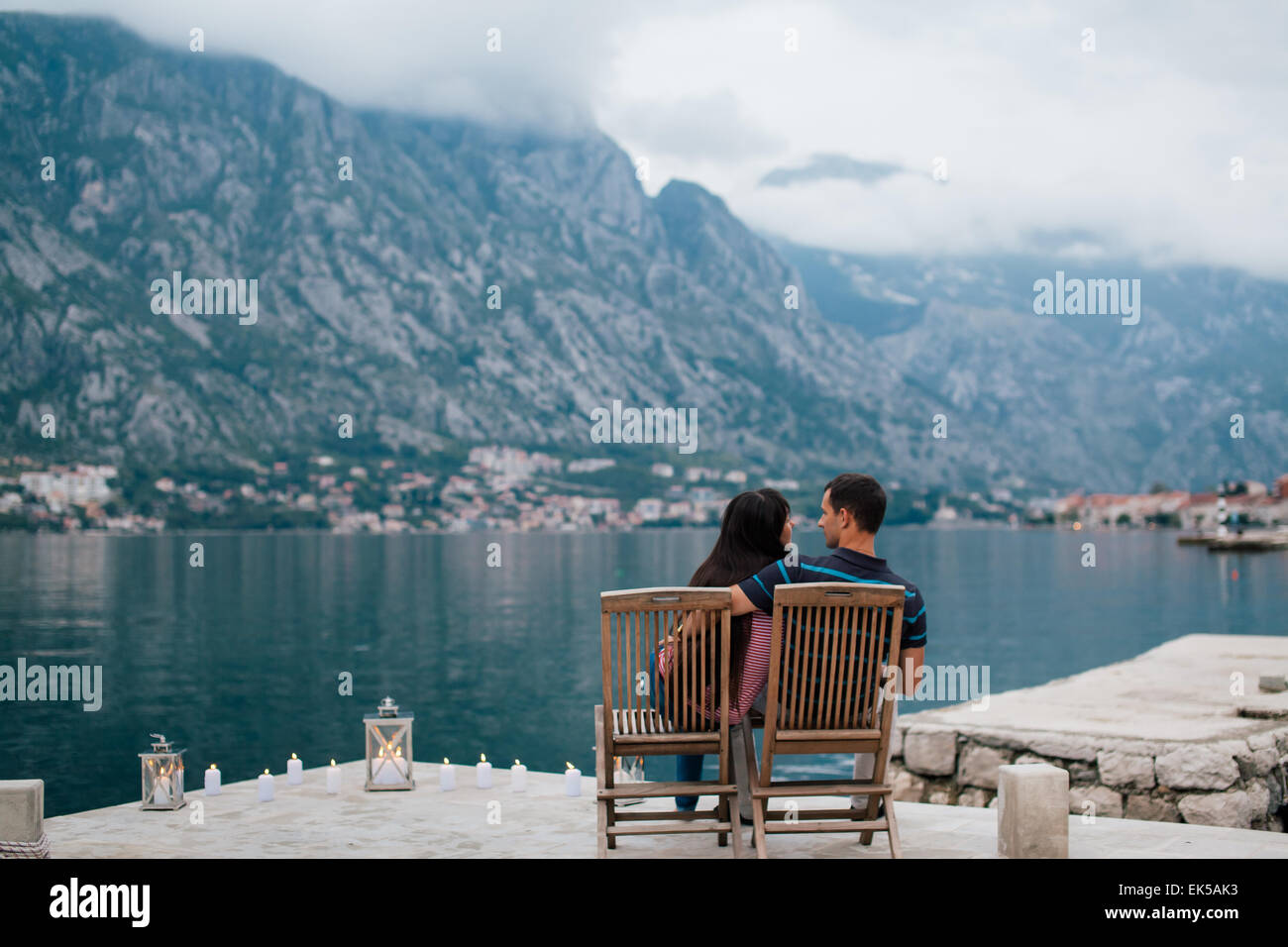 Coppia sulla spiaggia con candele in un posto romantico con la montagna e la vista sulla baia in Montenegro Foto Stock