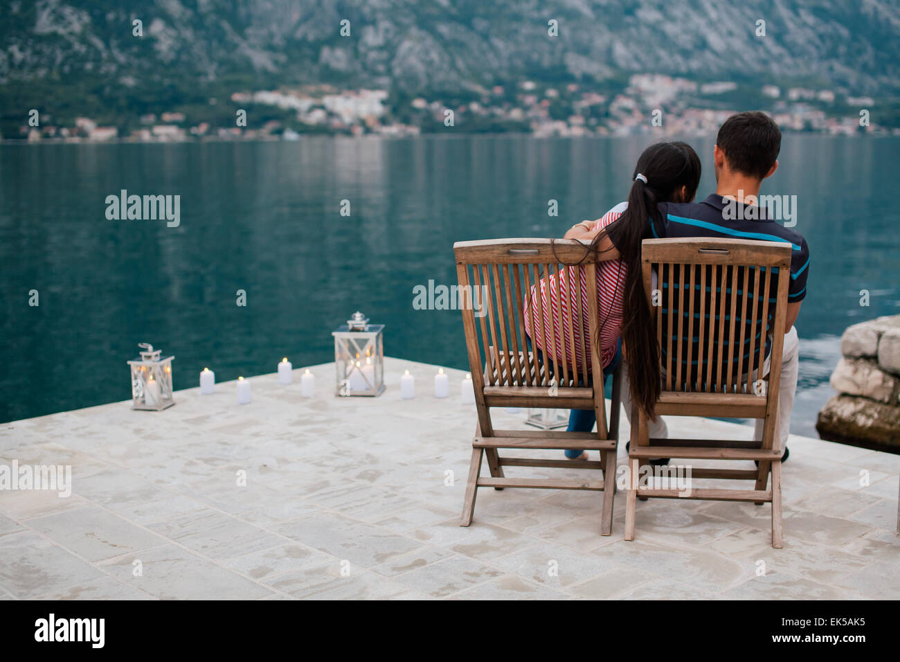 Coppia sulla spiaggia con candele in un posto romantico con la montagna e la vista sulla baia in Montenegro Foto Stock