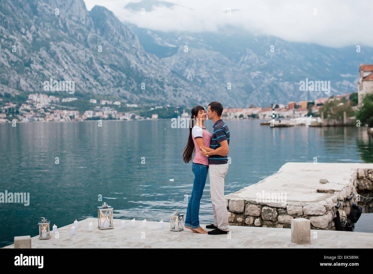 Coppia sulla spiaggia con candkes in un posto romantico con la montagna e la vista sulla baia in Montenegro Foto Stock