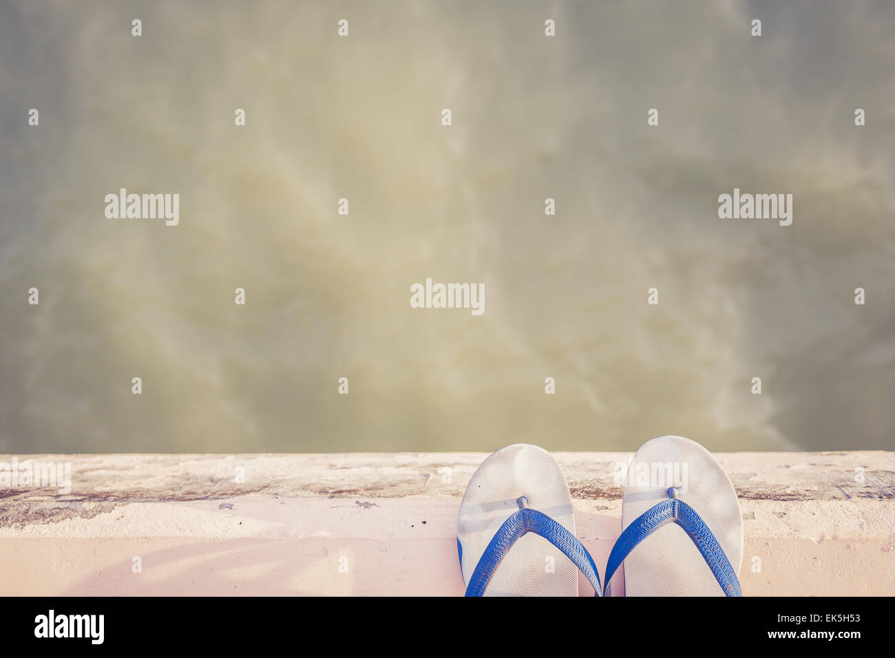 Bianco scarpa in gomma sul bordo di cemento vicino al mare, Retro per effetto del filtro Foto Stock
