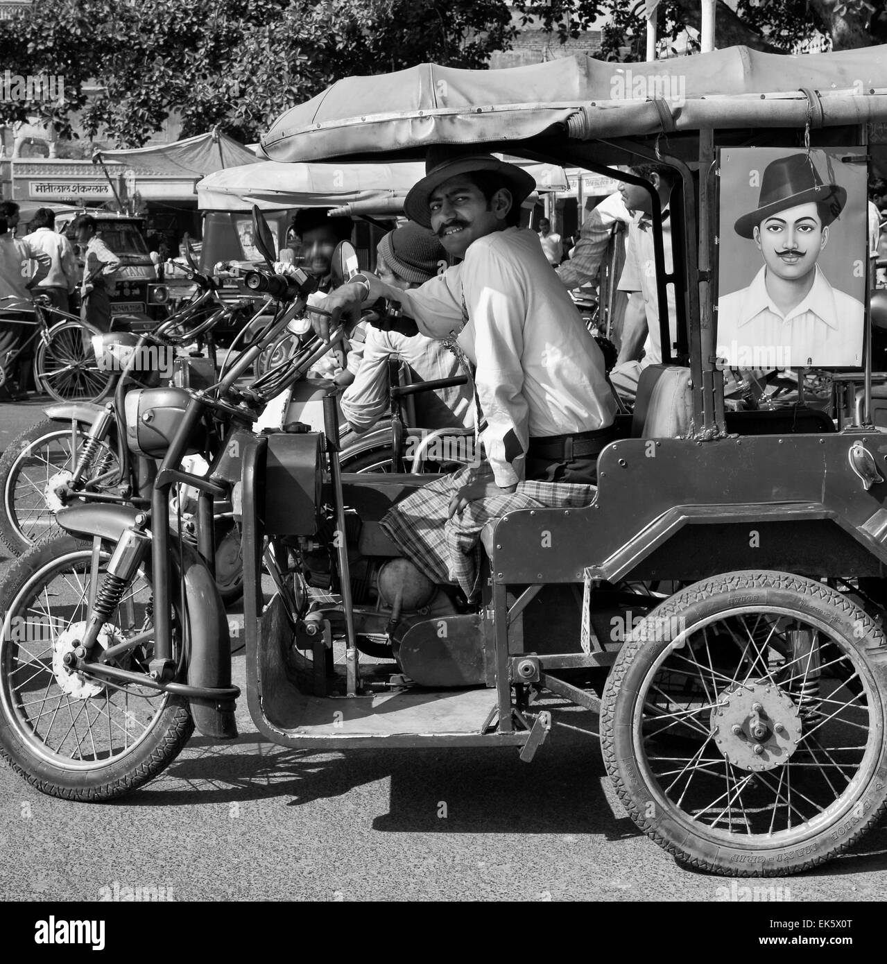 India Rajasthan, Jaipur, indiano tuk tuk driver con il suo ritratto in una via centrale della città Foto Stock