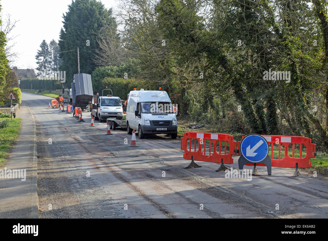Un team di lavori stradali installa il nuovo a banda larga ad alta velocità i cavi a fibre ottiche in un territorio rurale Oxfordshire village Foto Stock