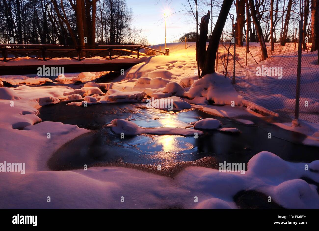 Un congelati scenic piccolo fiume in inverno sera presso il blue ore. Foto Stock
