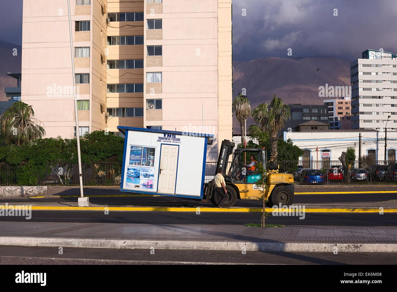 IQUIQUE, Cile - 22 gennaio 2015: persona non identificata il sollevamento di un piccolo stand con un carrello elevatore a forche su Arturo Prat Chacon avenue Foto Stock