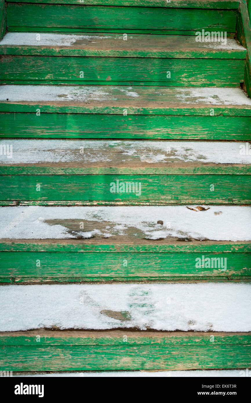 Closep delle vecchie scale di legno dipinte di verde ricoperto di neve Foto Stock