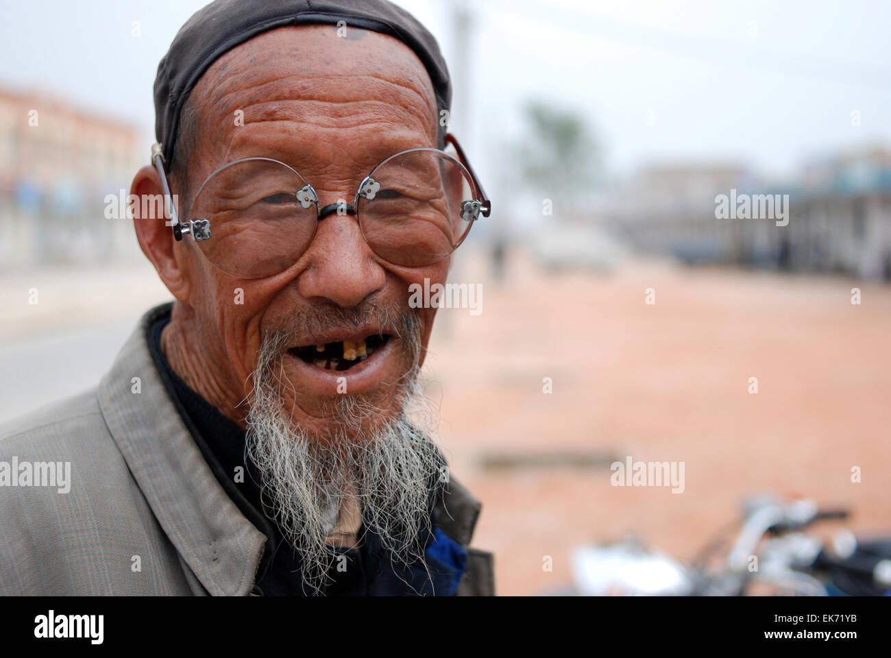 Un viaggio attraverso la Cina, ho trovato questo anziano gentiluomo nel Gansu. Amore la faccia e bicchieri. Foto Stock