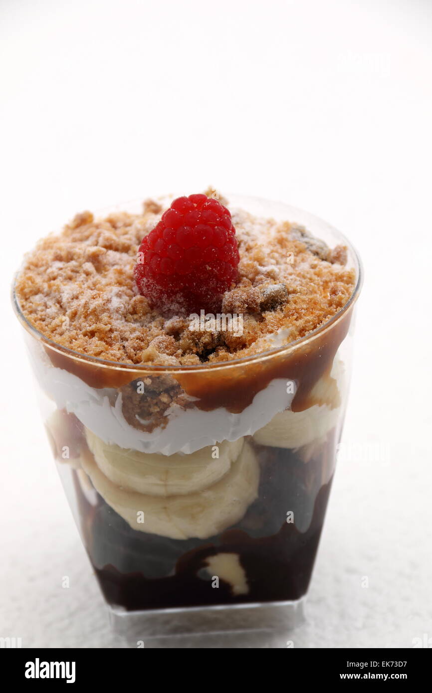 Banoffee pie in un bicchiere rovesciato con caremel e panna montata Foto Stock