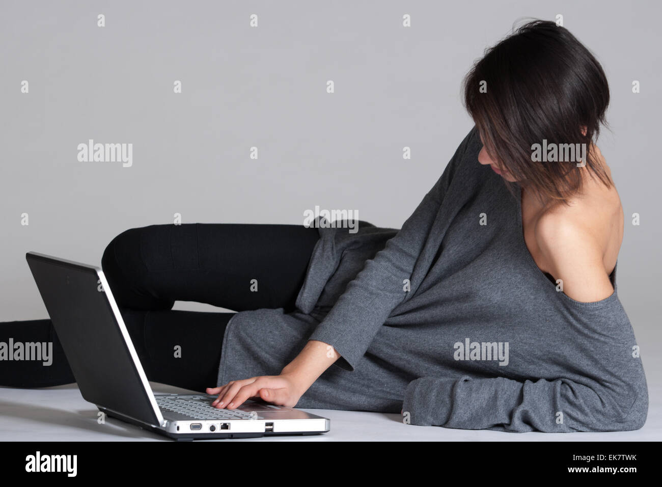 Giovane donna sul pavimento con i notebook Foto Stock