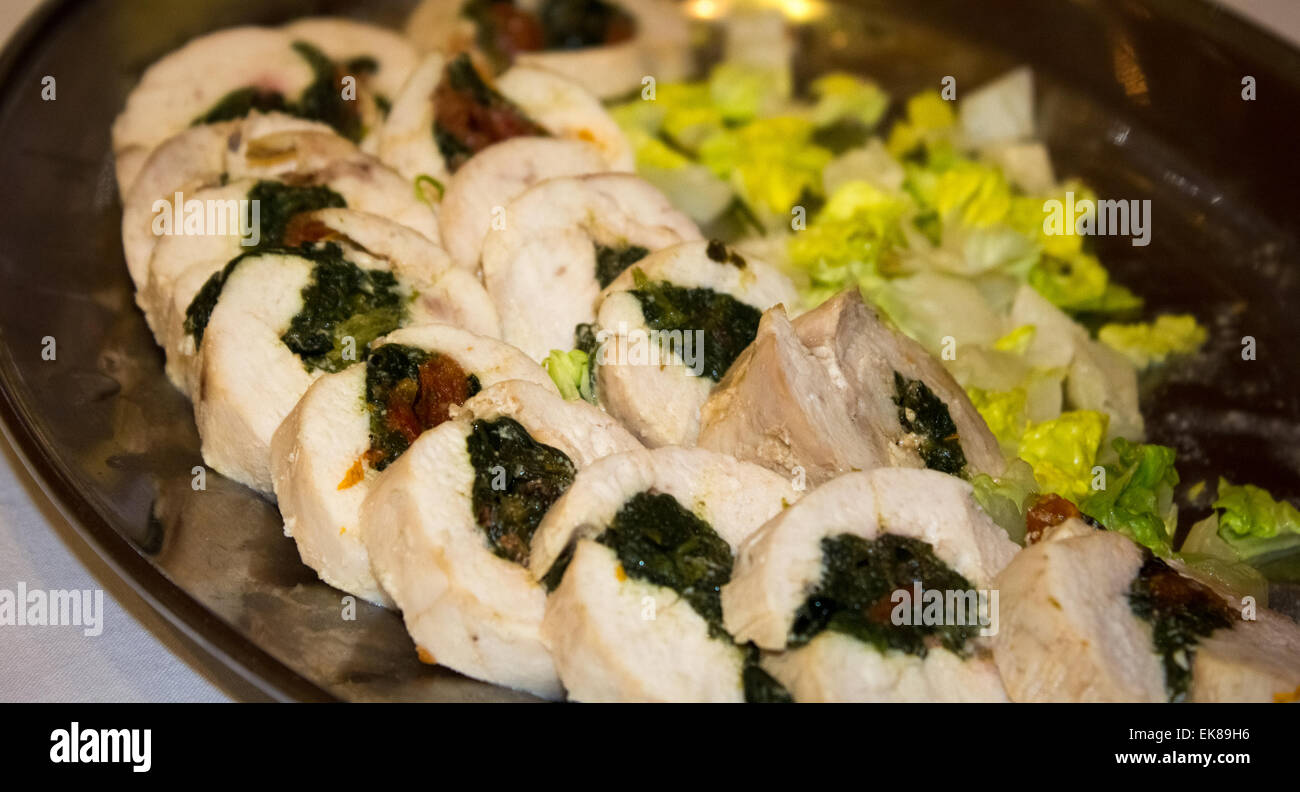 Tartine di pollo ripieni di spinaci e salsa di mirtilli con lattuga sul lato su una piastra in corrispondenza di un area VIP dello spettacolo. Foto Stock