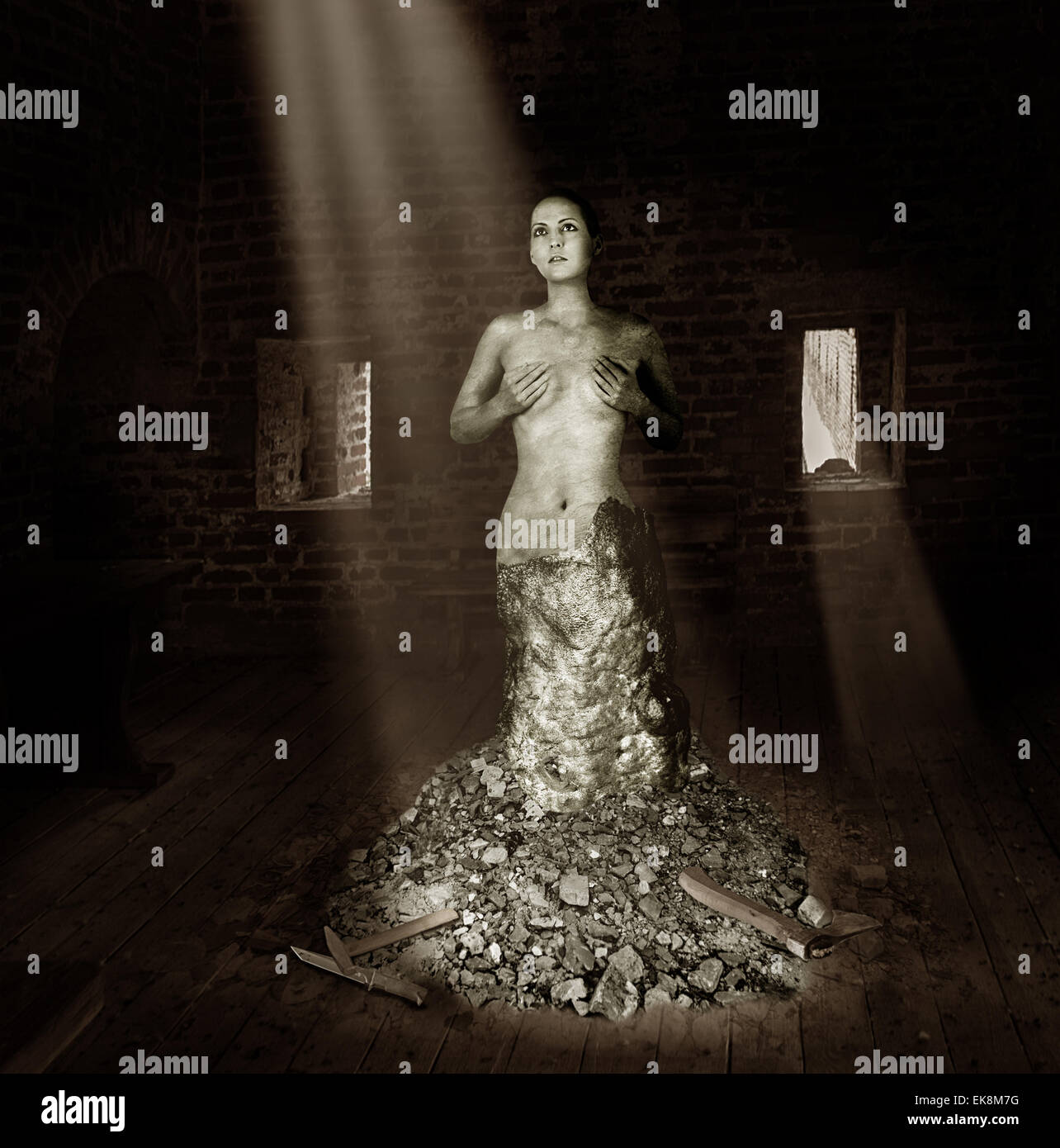 Statua di una donna in pietra sorge nel vecchio studio nei raggi di luce Foto Stock