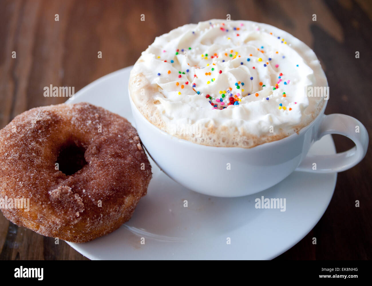 Un caldo Torta di compleanno latté con spruzzi di colore e la panna e lo zucchero cannella ciambella. Foto Stock