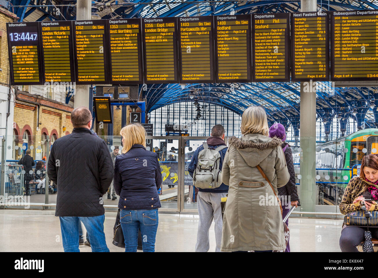 Un paesaggio immagine di passeggeri guardando la stazione di Brighton orario di partenza del treno bordo, Brighton,West Sussex England Regno Unito Foto Stock