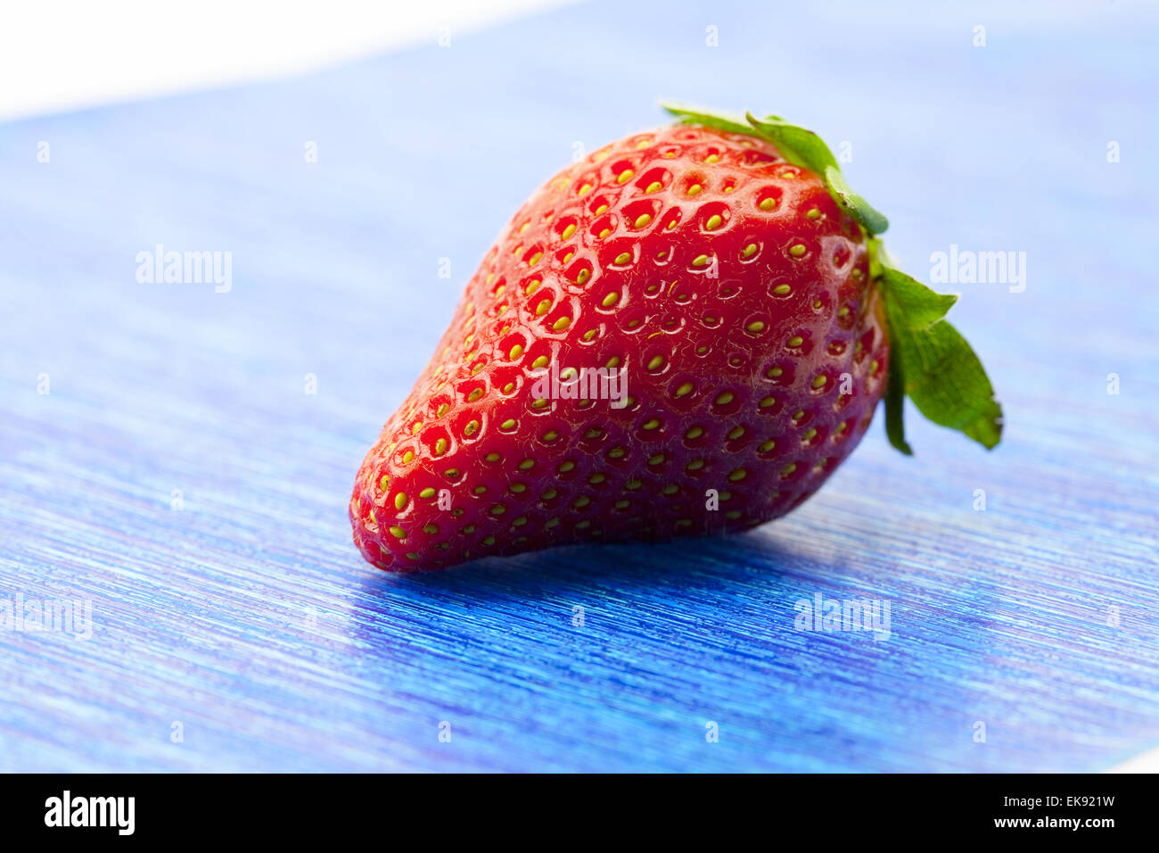 Fragole su carta blu Foto Stock