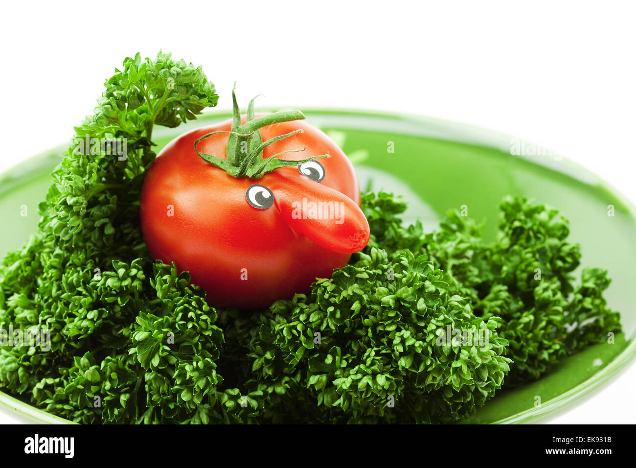 Il pomodoro con un naso su una piastra verde isolato su bianco Foto Stock