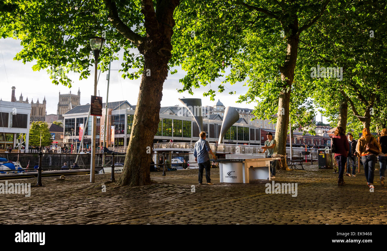 Giocando a ping-pong presso uno dei molti tavoli attorno alla città di Bristol. Questo è sulla strada di ciottoli vicino al dock. Foto Stock