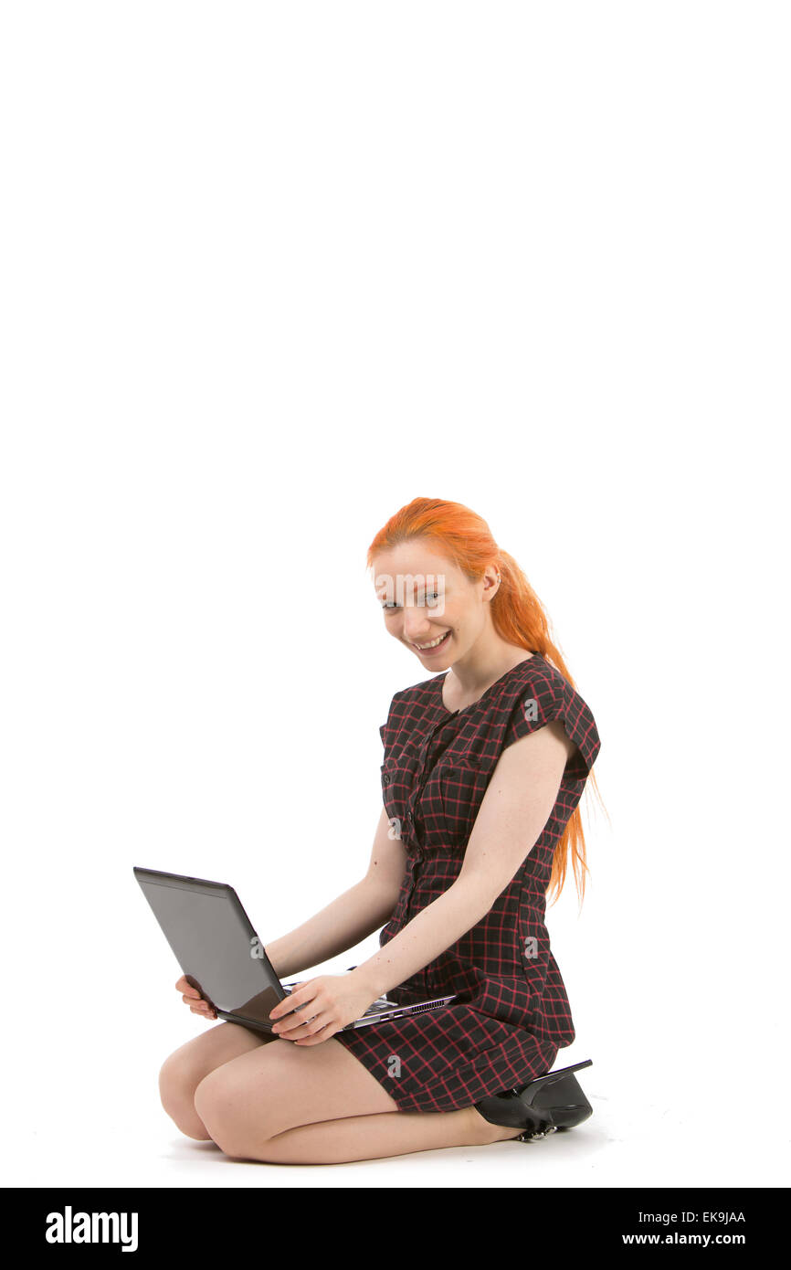Sorridente redhead usando il suo computer portatile Foto Stock