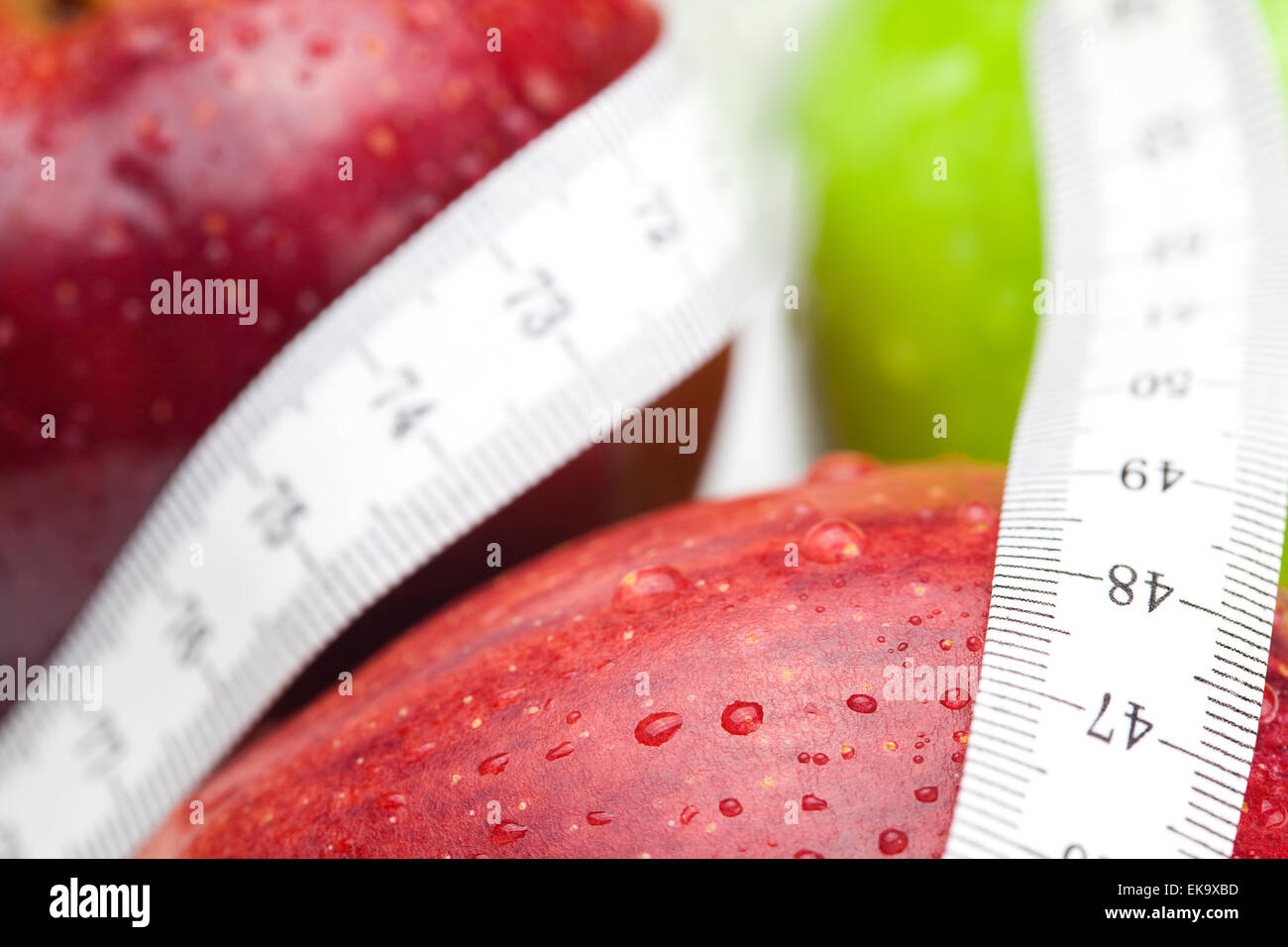 Apple con gocce di acqua e nastro di misura isolati su bianco Foto Stock