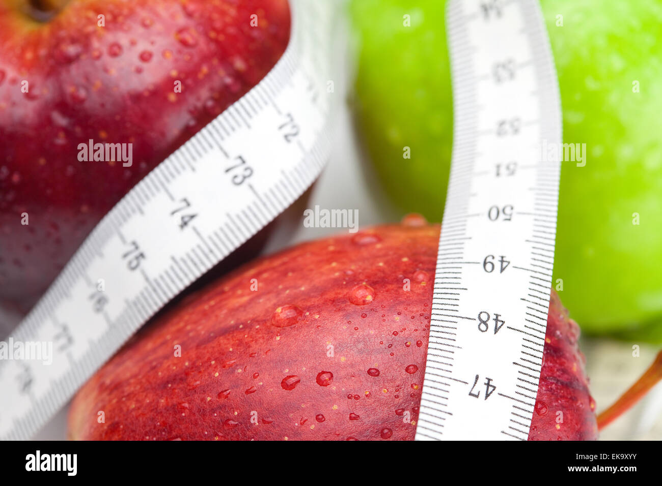 Apple con gocce di acqua e nastro di misura isolati su bianco Foto Stock