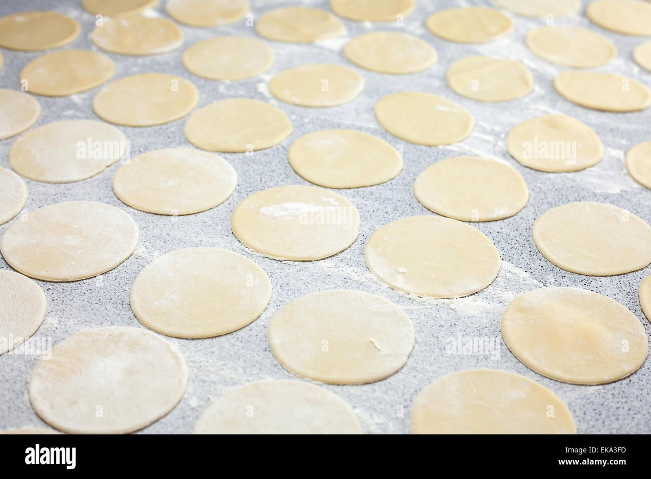 La forma rotonda della pasta con farina sul tavolo Foto Stock