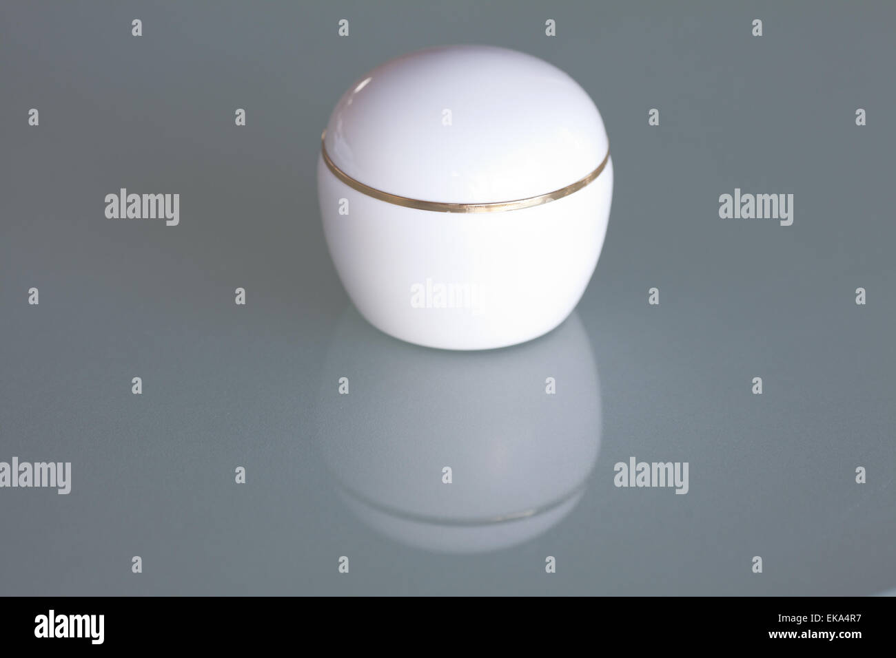 Un contenitore cosmetico sulla superficie del vetro Foto Stock