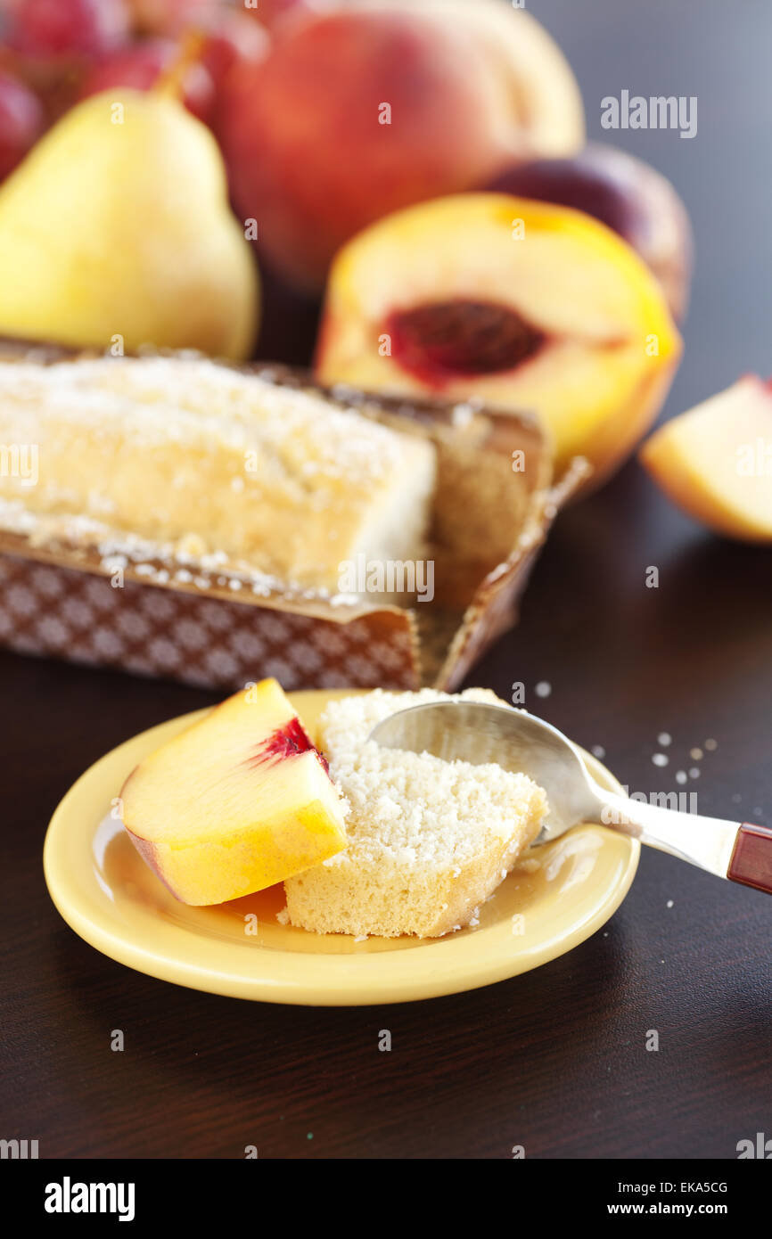 Pesca, pera, susina, Torta al cocco,cucchiaio e uva su una scheda in legno Foto Stock