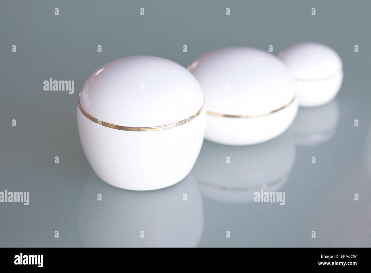 Tre contenitore cosmetico sulla superficie del vetro Foto Stock