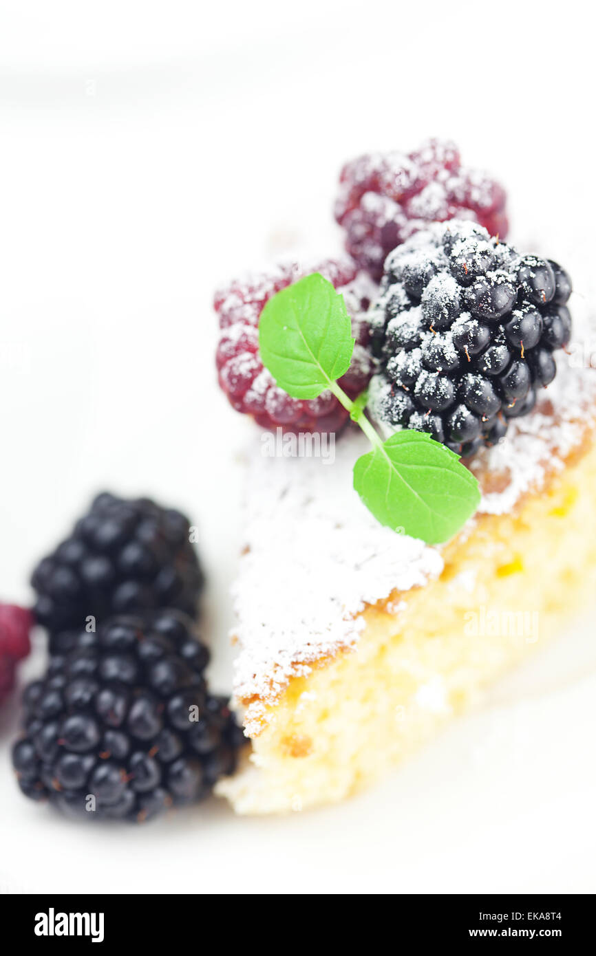 La torta con la glassa, lampone, mora e menta su un retro bianco Foto Stock