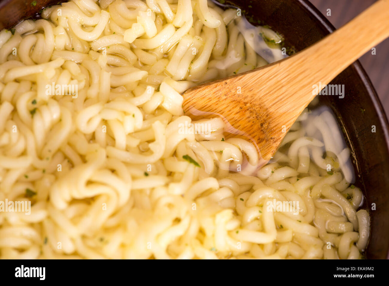 Zuppa di spaghetti istantanei in una ciotola di legno Foto Stock