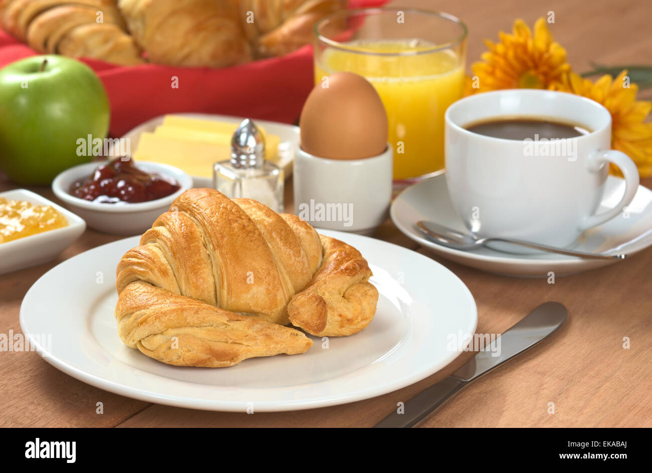 La deliziosa prima colazione continentale composta da caffè, succo d'arancia, croissant, uova sode, marmellata, burro e Apple Foto Stock