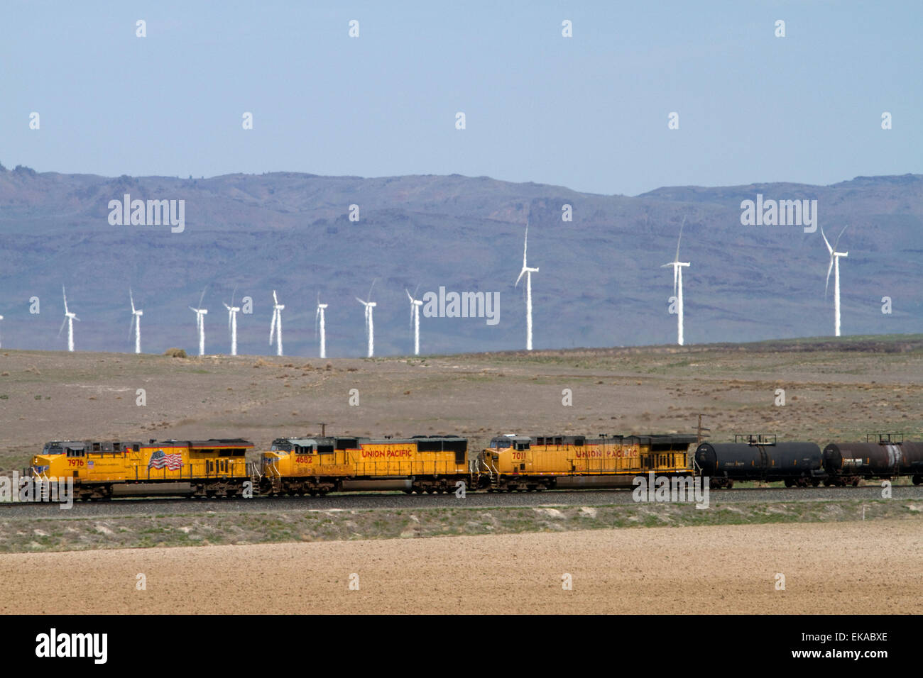 Union Pacific Railroad treno viaggiando attraverso una linea di vento powered generatori elettrici di Elmore County, Idaho, Stati Uniti d'America. Foto Stock