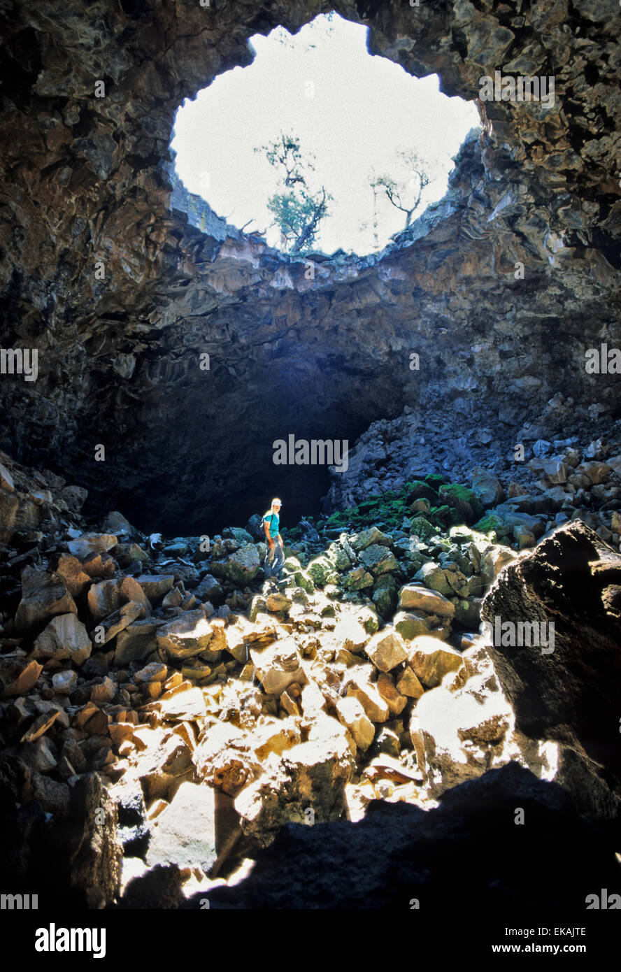 Un escursionista sorge in un sumbeam nelle grotte di lava a El Malpais Monumento Nazionale vicino a sovvenzioni, Nuovo Messico Foto Stock