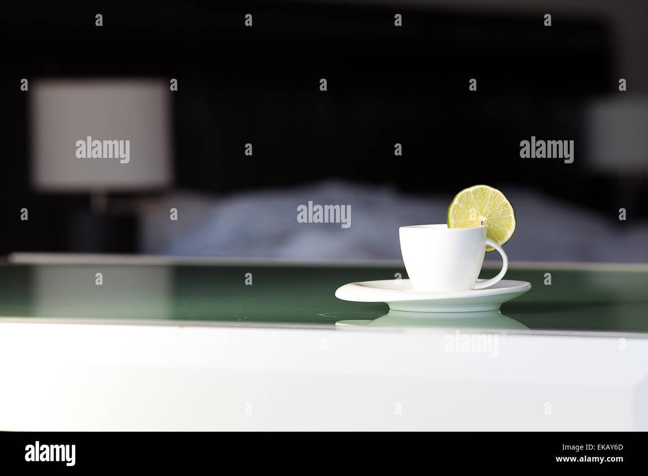 Il tè con limone sullo sfondo del letto e la lampada Foto Stock