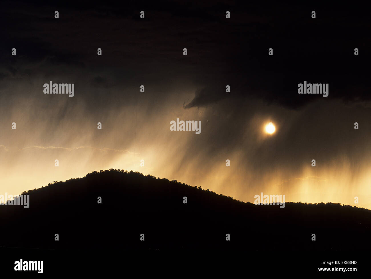 Un acquazzone estivo è un evento che passa nel New Mexico settentrionale, dove i picchi di sole fuori da sotto le nuvole. Foto Stock