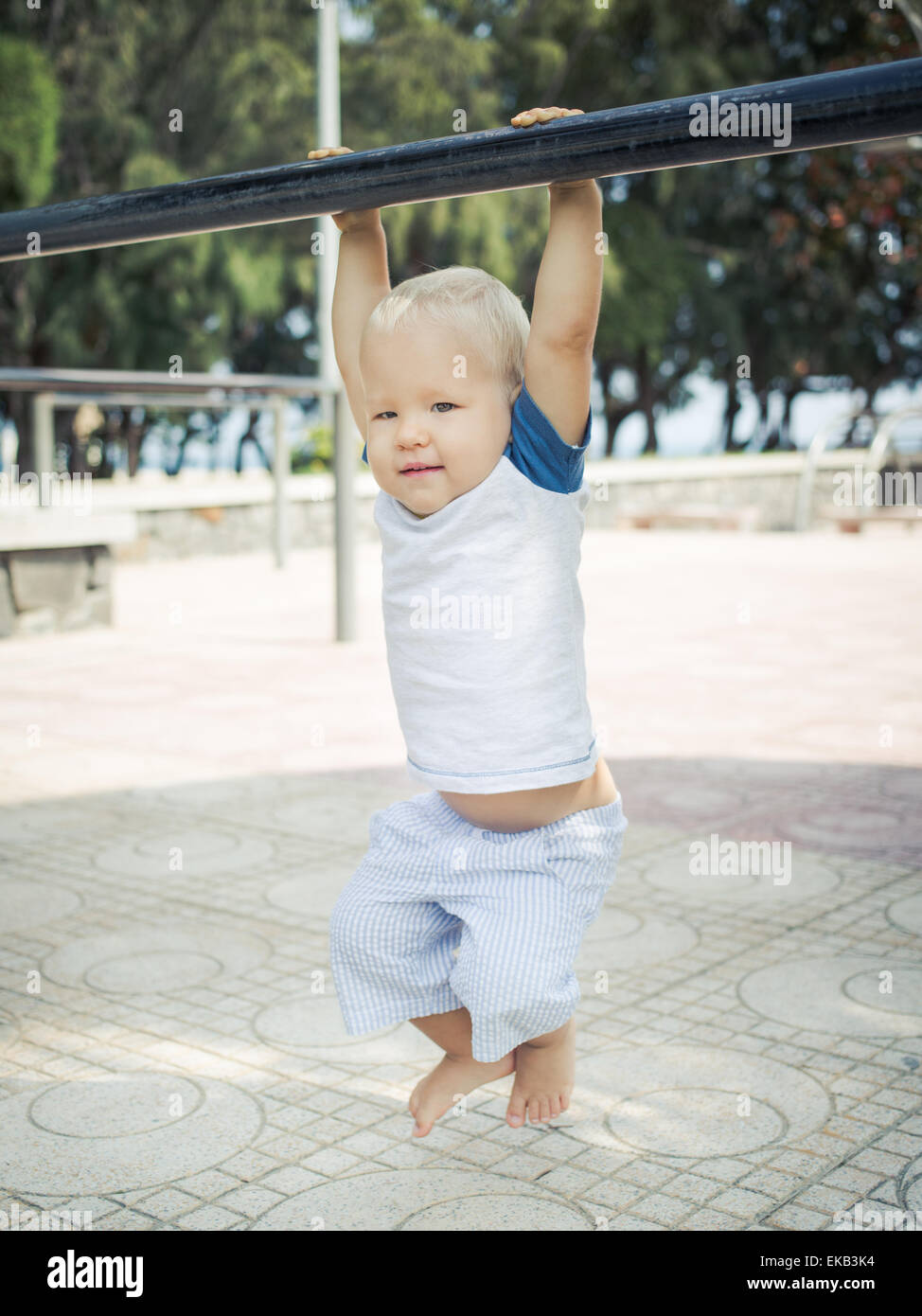 Baby appeso su un pull-up bar Foto Stock