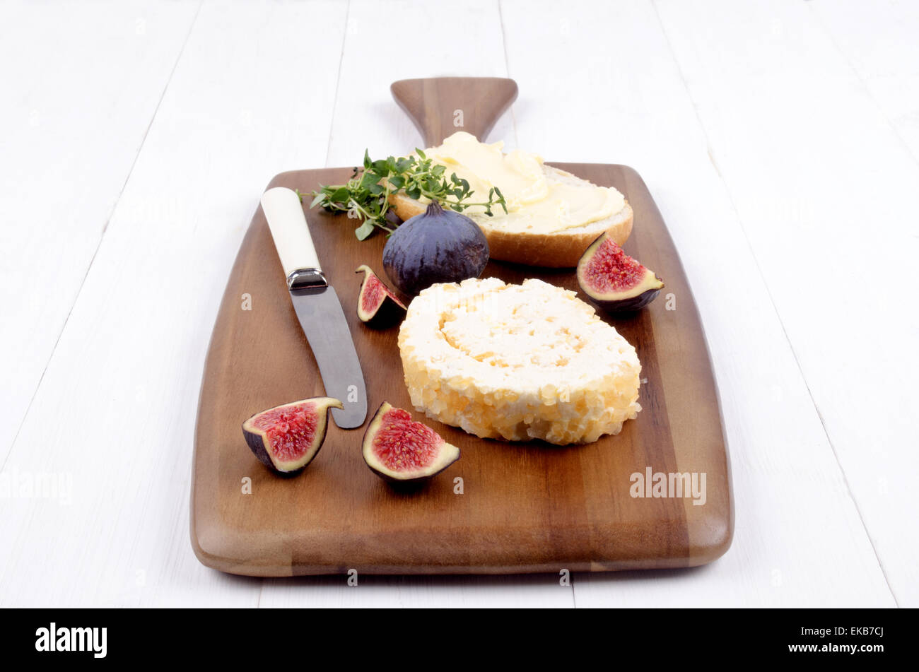 Ananas formaggio a pasta morbida, timo, fig e una fetta di pane con burro su una tavola di legno Foto Stock
