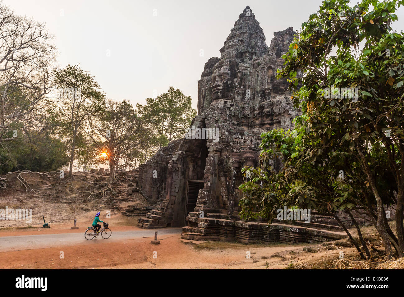 Andando in bicicletta attraverso la porta sud di Angkor Thom a sunrise, Angkor, UNESCO, Siem Reap Provincia, Cambogia, Indocina, Asia Foto Stock