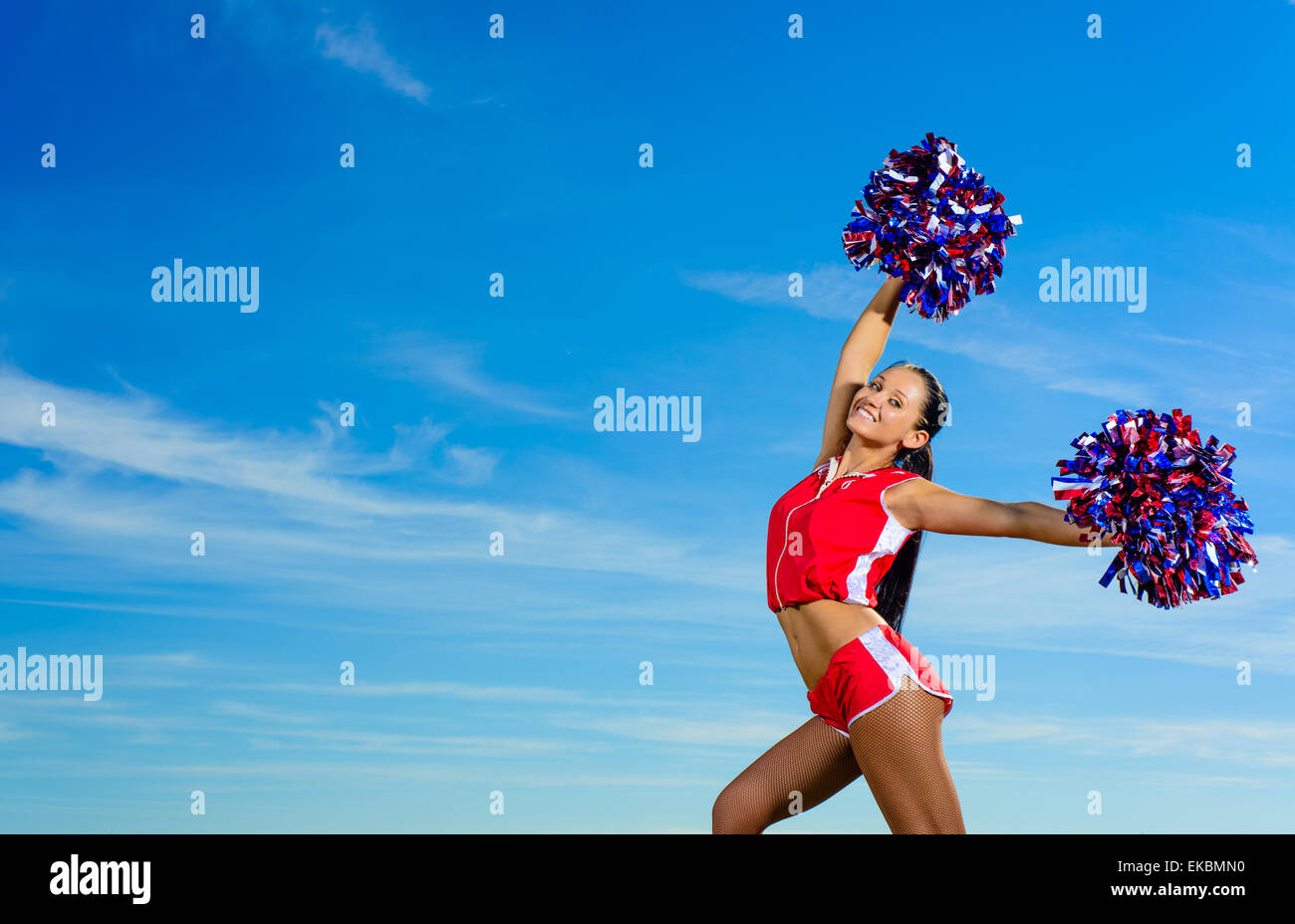 Giovani cheerleader in costume rosso con pampon Foto Stock
