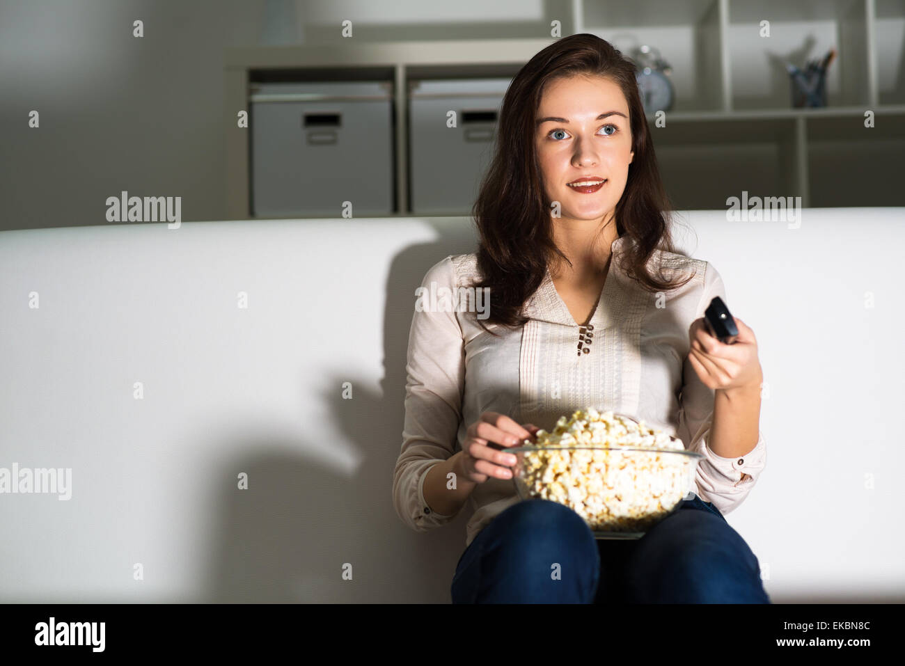 Giovane donna di guardare la TV Foto Stock