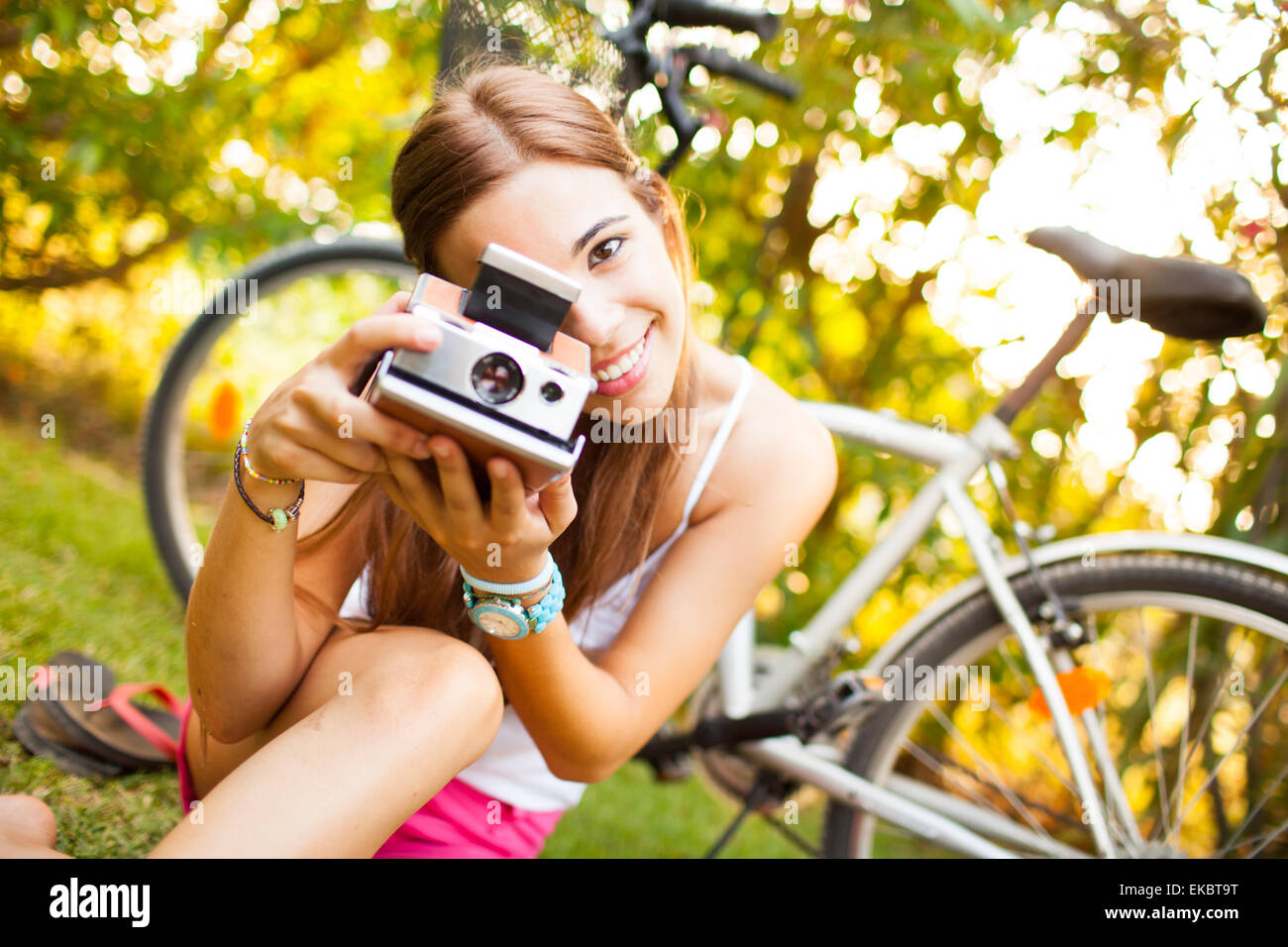 Giovane e bella donna che gioca con una fotocamera vintage Foto Stock