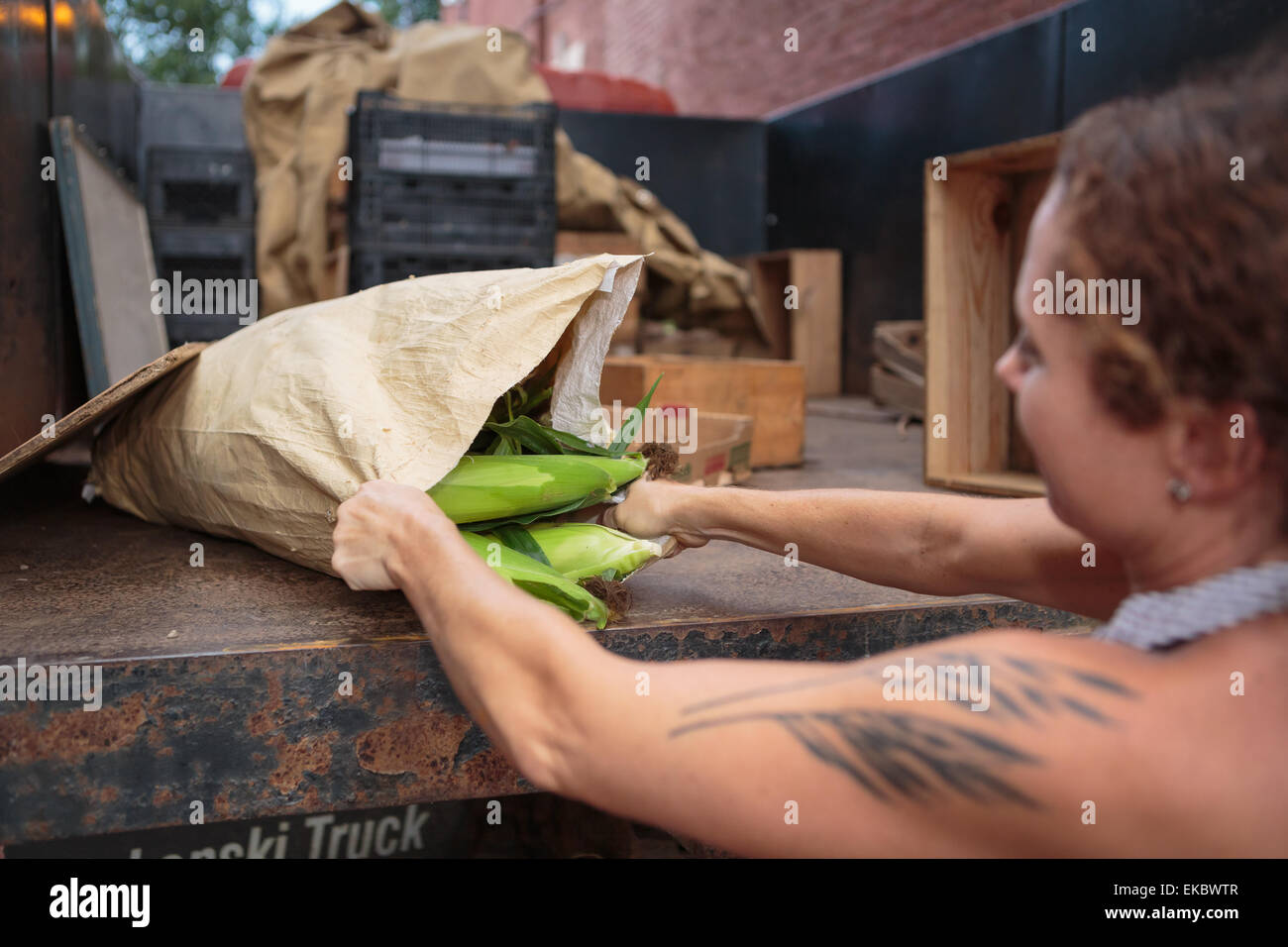 Titolare di stallo lo scarico dei sacchi di alimenti biologici per il negozio Foto Stock
