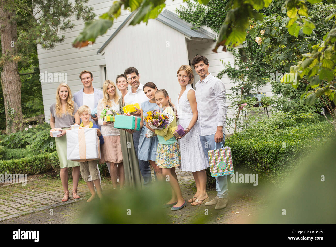 Ritratto di tre generazioni della famiglia in giardino con regali di compleanno Foto Stock