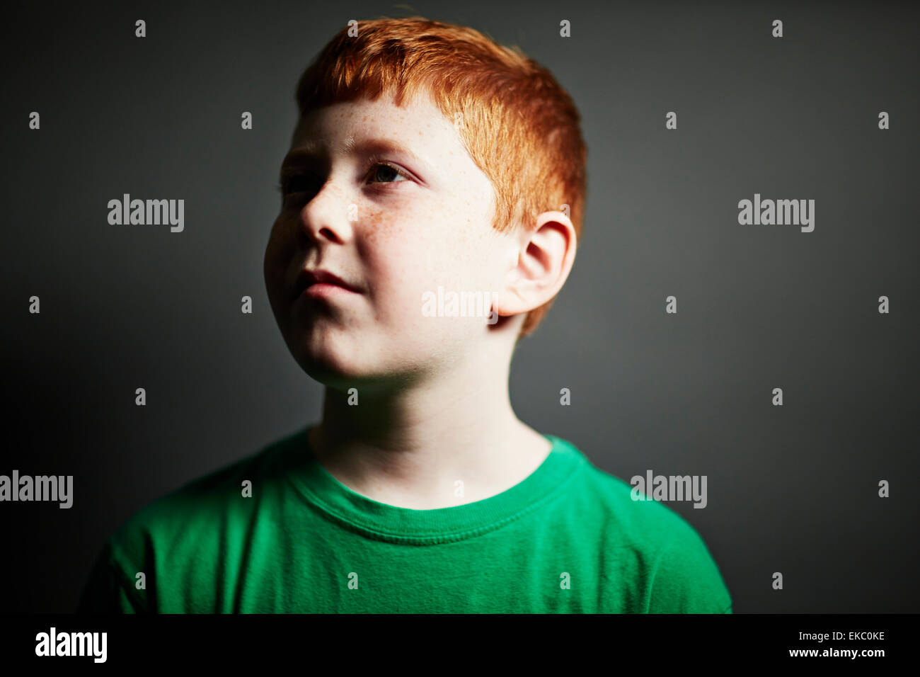 Ragazzo con i capelli rossi che guarda lontano Foto Stock