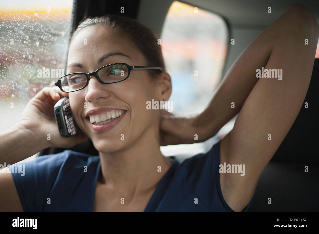Donna seduta nel sedile del passeggero di auto, utilizzando il telefono cellulare Foto Stock
