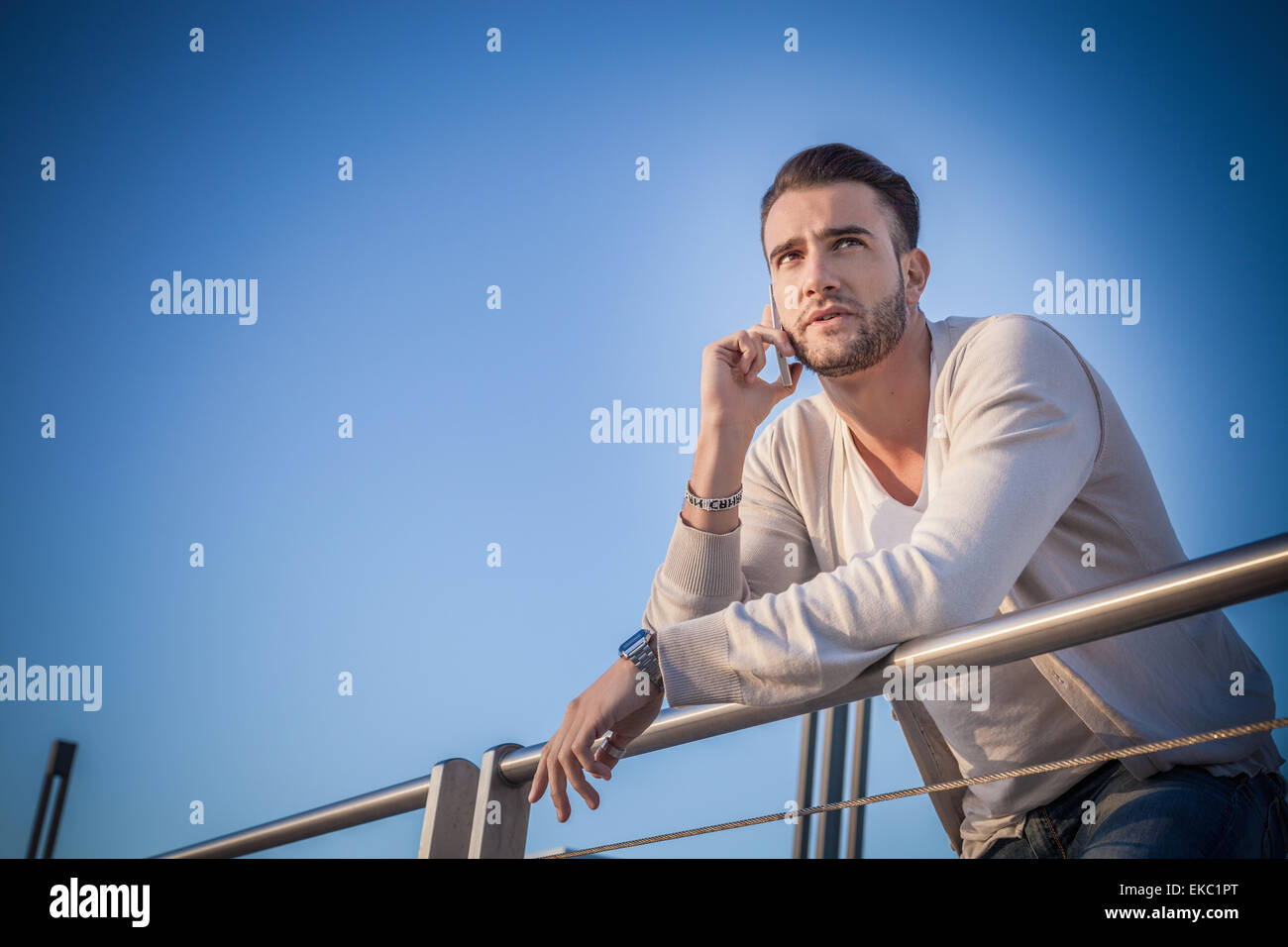 Giovane uomo utilizza lo smartphone tramite la porta Foto Stock